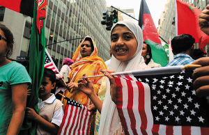 每年9月的第四个周日是美国穆斯林日。2012年的主题为“美国的未来。伊斯兰教！”图为纽约穆斯林手持美国国旗在游行。 资料图片